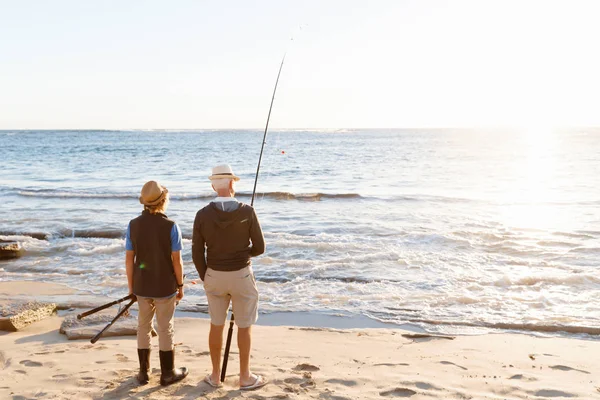 Hombre mayor pescando con su nieto — Foto de Stock