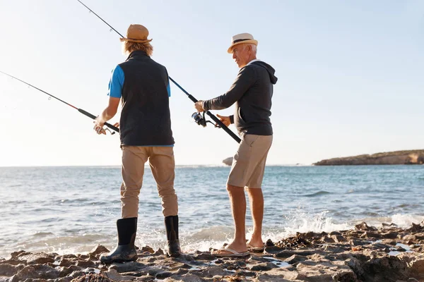 Uomo anziano pesca con suo nipote — Foto Stock