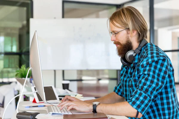 Genç adam ofiste çalışıyor.