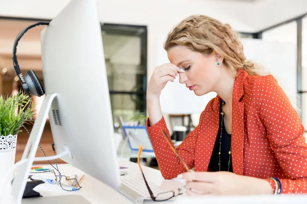 Mujer joven en la oficina cansada — Foto de Stock