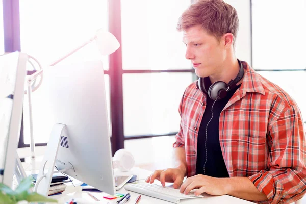 Genç adam ofiste çalışıyor.