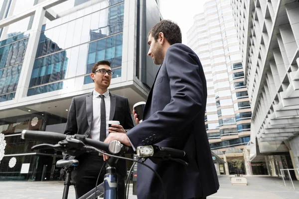 İki genç işadamları ile bir bisiklet şehir merkezinde