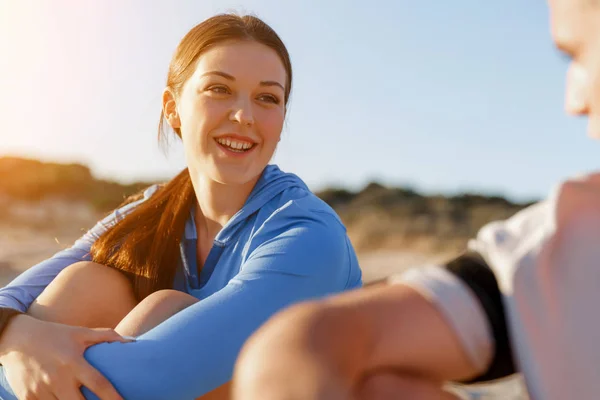 Couple en tenue de sport sur la plage — Photo