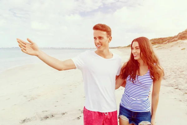 Glückliches junges Paar beim gemeinsamen Spaziergang am Strand — Stockfoto