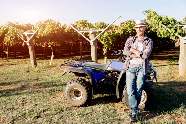 Uomo in piedi accanto al camion in vigna — Foto Stock