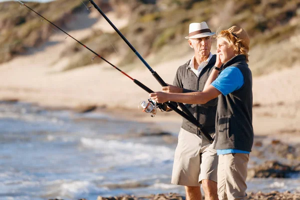 Uomo anziano pesca con suo nipote — Foto Stock