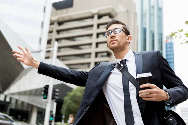 Jóvenes hombres de negocios pidiendo un taxi — Foto de Stock