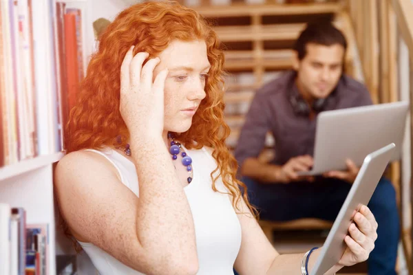 Portrait of two young people sitting at the stairs in office — Stock Photo, Image