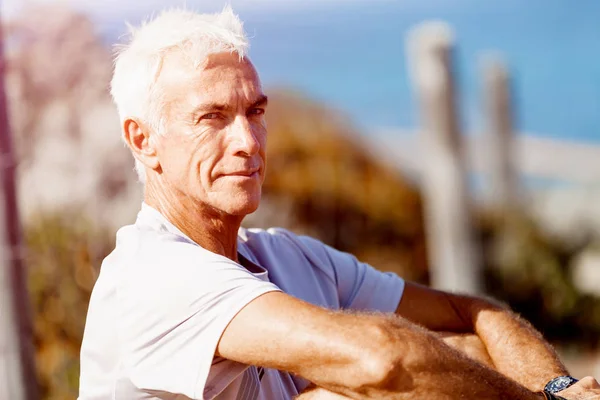 Man in sports wear sitting at the beach Stock Photo