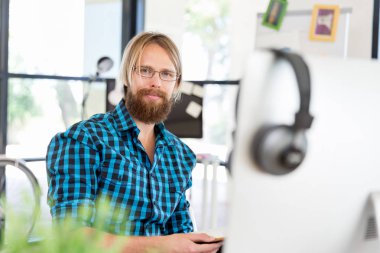 Genç adam ofiste çalışıyor.