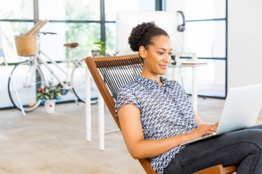 Afro-Amerikan ofis çalışanı iş içinde oturan gülümseyen portresi