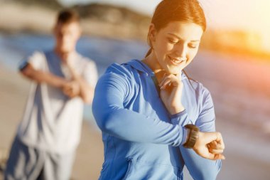 Kalp atış hızı monitörünü plajda çalışan kadınla Runner