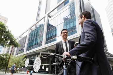 İki genç işadamları ile bir bisiklet şehir merkezinde