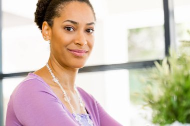 Afro-Amerikan ofis çalışanı iş içinde oturan gülümseyen portresi