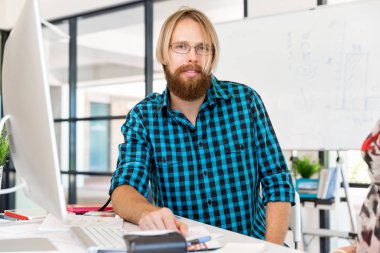 Genç adam ofiste çalışıyor.