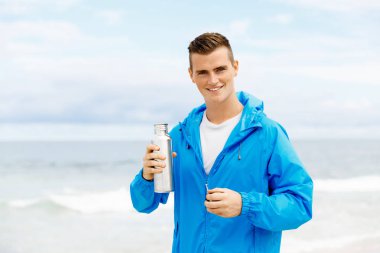 Şişe su ile tutarak kendine güvenen genç adam