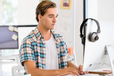 Genç adam ofiste çalışıyor.