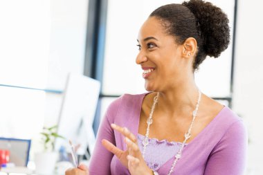 Afro-Amerikan ofis çalışanı iş içinde oturan gülümseyen portresi