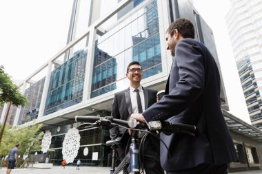 İki genç işadamları ile bir bisiklet şehir merkezinde