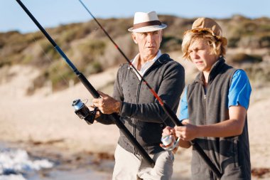 Yaşlı adam torunuyla balık tutuyor.