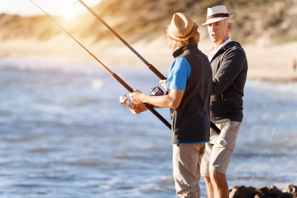 Uomo anziano pesca con suo nipote — Foto Stock