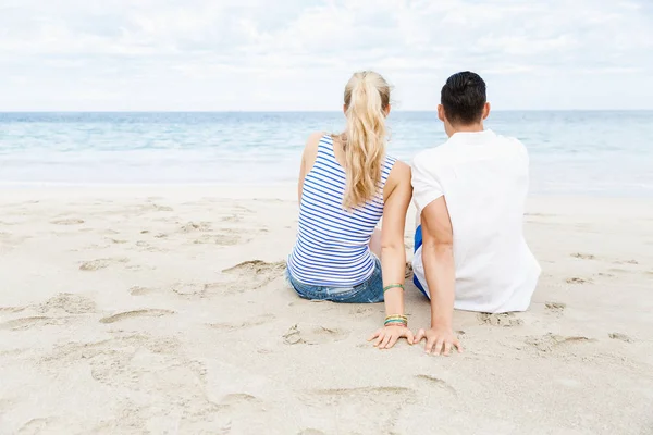 Romantikus, fiatal pár ül a strandon — Stock Fotó