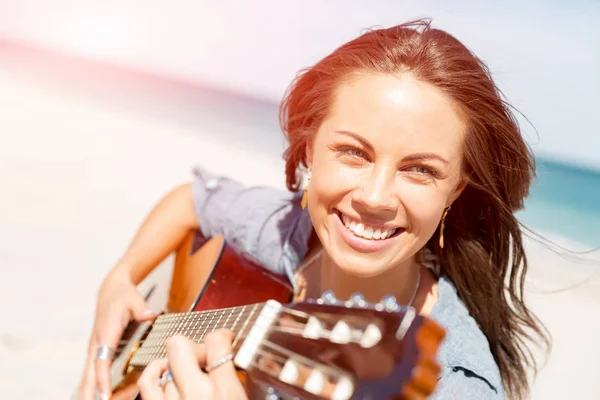 Красива молода жінка грає на гітарі на пляжі — стокове фото