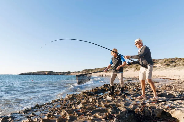 Yaşlı adam torunuyla balık tutuyor.