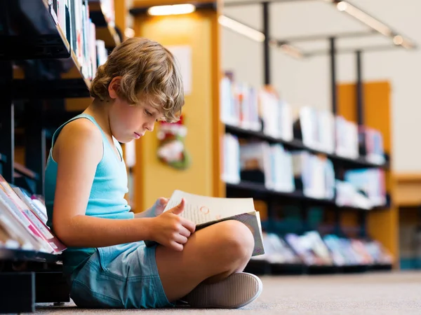 Jongen in bibliotheek — Stockfoto