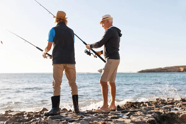 Yaşlı adam torunuyla balık tutuyor.