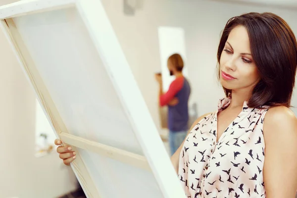 Mujer joven caucásica de pie en la galería de arte frente a las pinturas —  Fotos de Stock