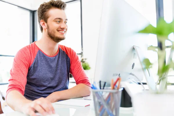 Genç adam ofiste çalışıyor.