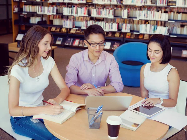 Group of young students at the library — Stock Photo, Image