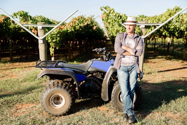 Uomo in piedi accanto al camion in vigna — Foto Stock