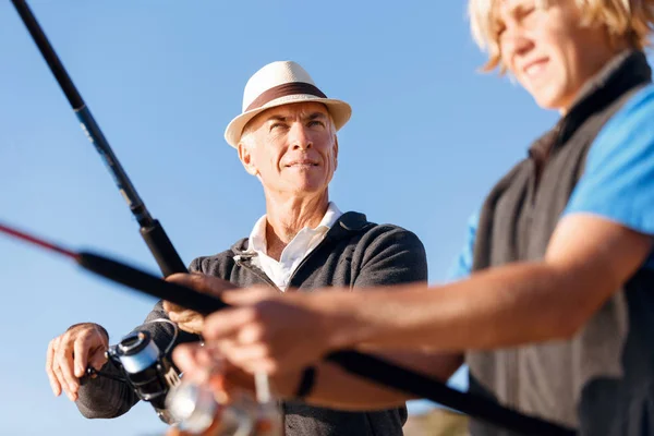 Uomo anziano pesca con suo nipote — Foto Stock