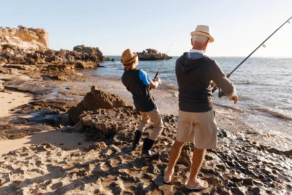 Hombre mayor pescando con su nieto — Foto de Stock