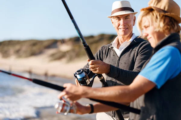 Uomo anziano pesca con suo nipote — Foto Stock