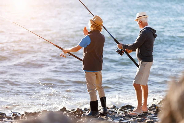 Uomo anziano pesca con suo nipote — Foto Stock