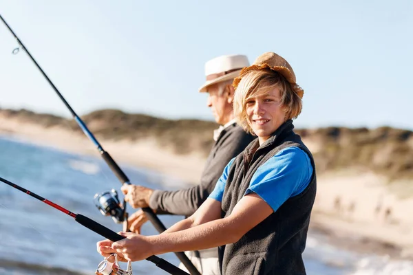 Uomo anziano pesca con suo nipote — Foto Stock