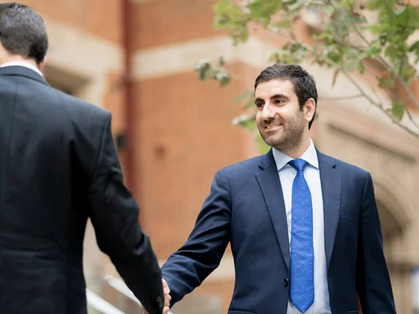 Dos hombres de negocios estrechando sus manos — Foto de Stock