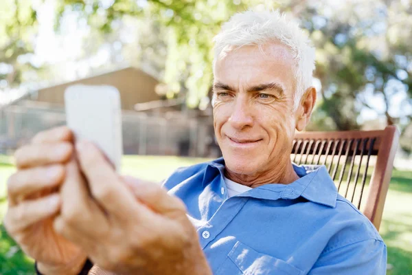 Lomature mężczyzna na zewnątrz przy użyciu telefonu komórkowego — Zdjęcie stockowe