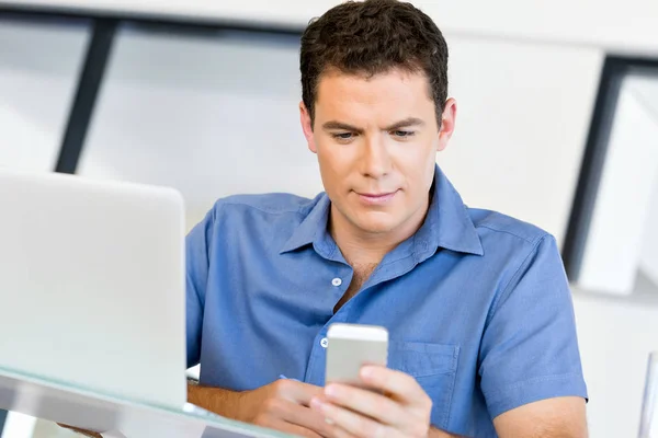 Confident young man in smart casual wear holding phone — Stock Photo, Image