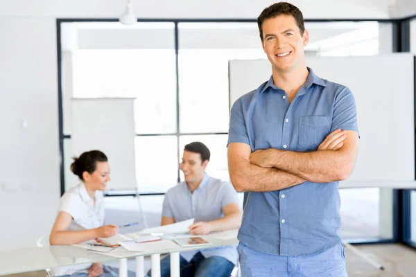 Young caucasian businessman standing in office — Stock Photo, Image