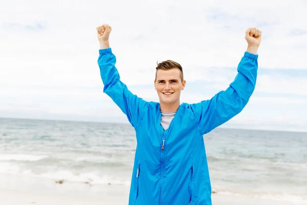 Young man in sport wear with outstretched arms — Stock Photo, Image