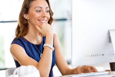 masada oturan ve çalışan genç iş kadını