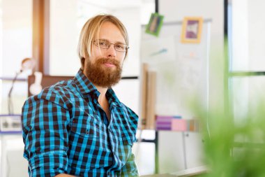 Genç adam ofiste çalışıyor.