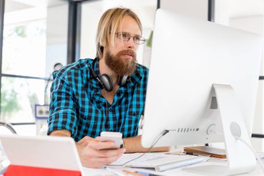 Genç adam ofiste çalışıyor.