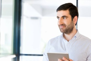 Genç yakışıklı işadamı onun touchpad ayakta kullanma office