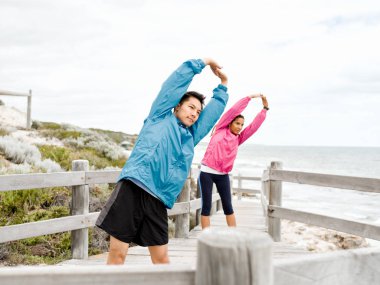 Egzersizleri yapıyor deniz kenarında genç Çift