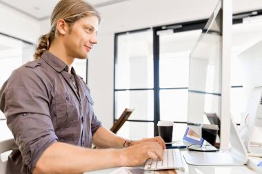 Bilgisayarda çalışan yakışıklı işadamı